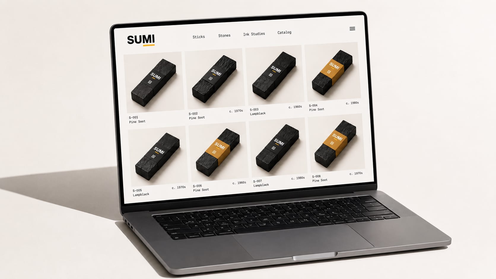 The Sumi homepage on a 14-inch laptop, showing a clean catalog-grid layout with the SUMI wordmark, a horizontal navigation, and a four-column grid of ink-stick product thumbnails, each labeled with catalog number, soot type, and vintage